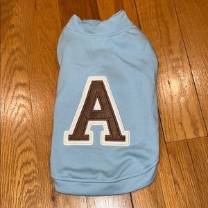 Blue dog jacket with Letterman style a on the back. Snap closure on chest.